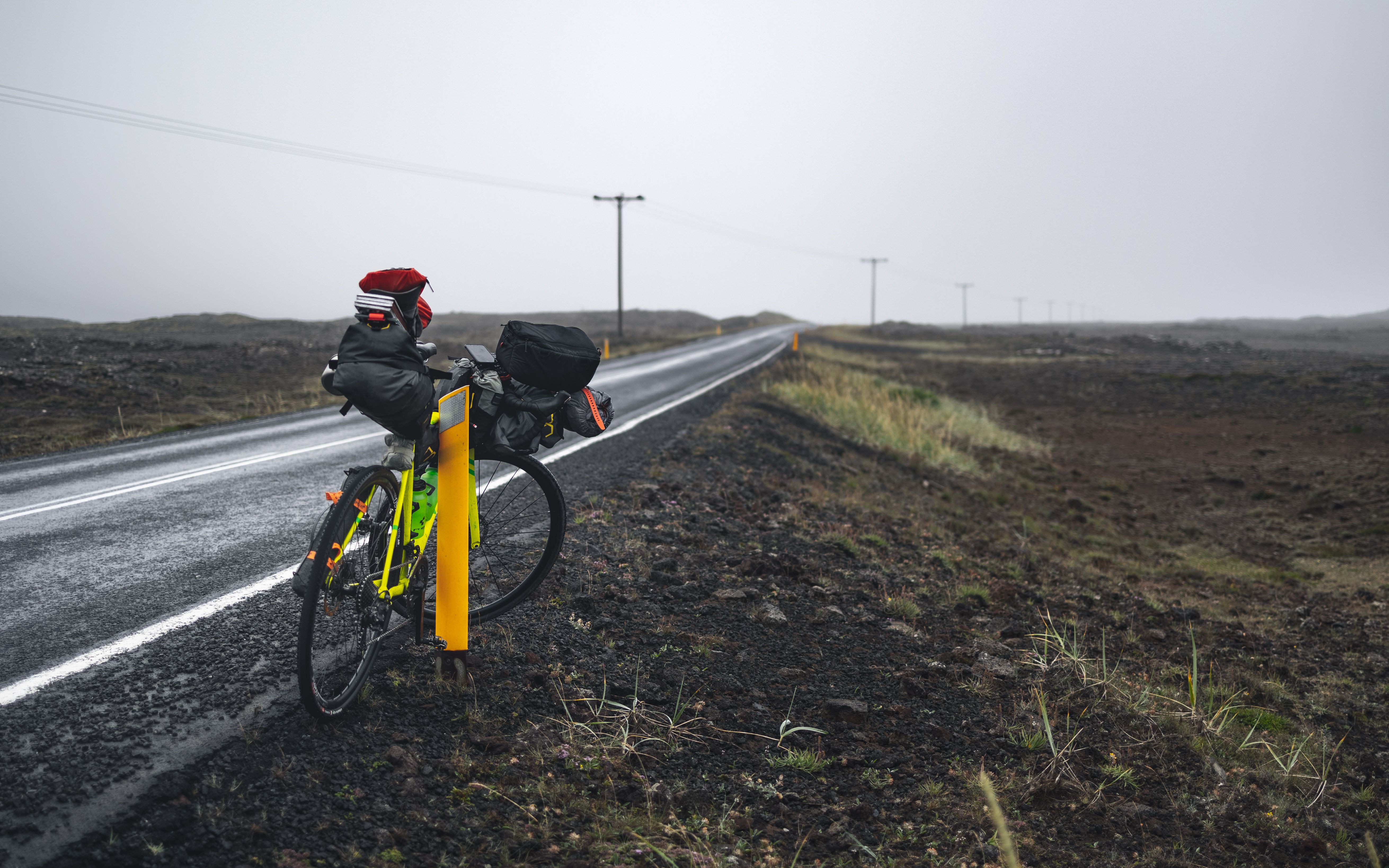 Volgepakte toerfiets met fietstassen langs een stille weg