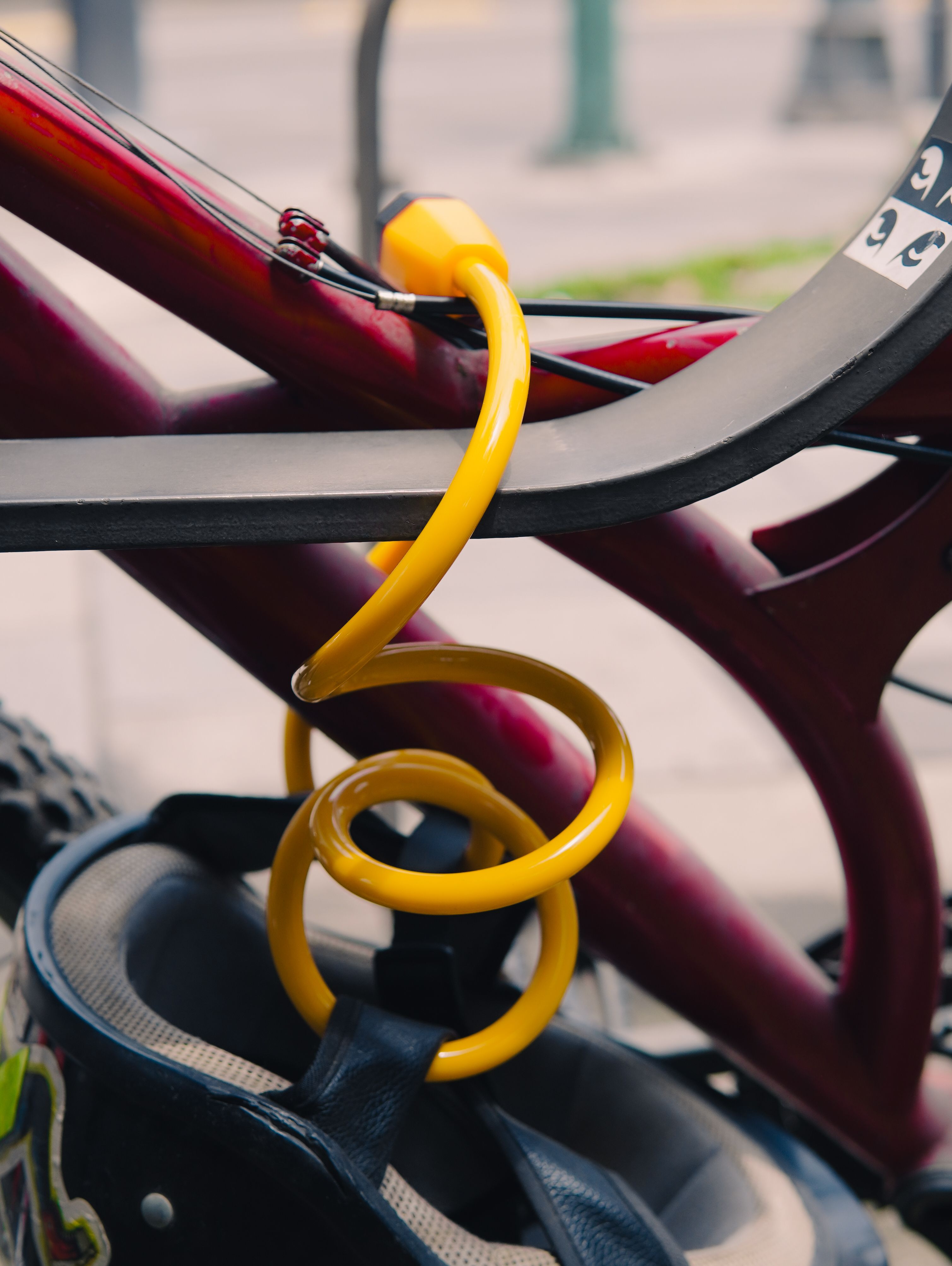 Geel fietsslot dat een fiets buiten vastzet aan een beugel