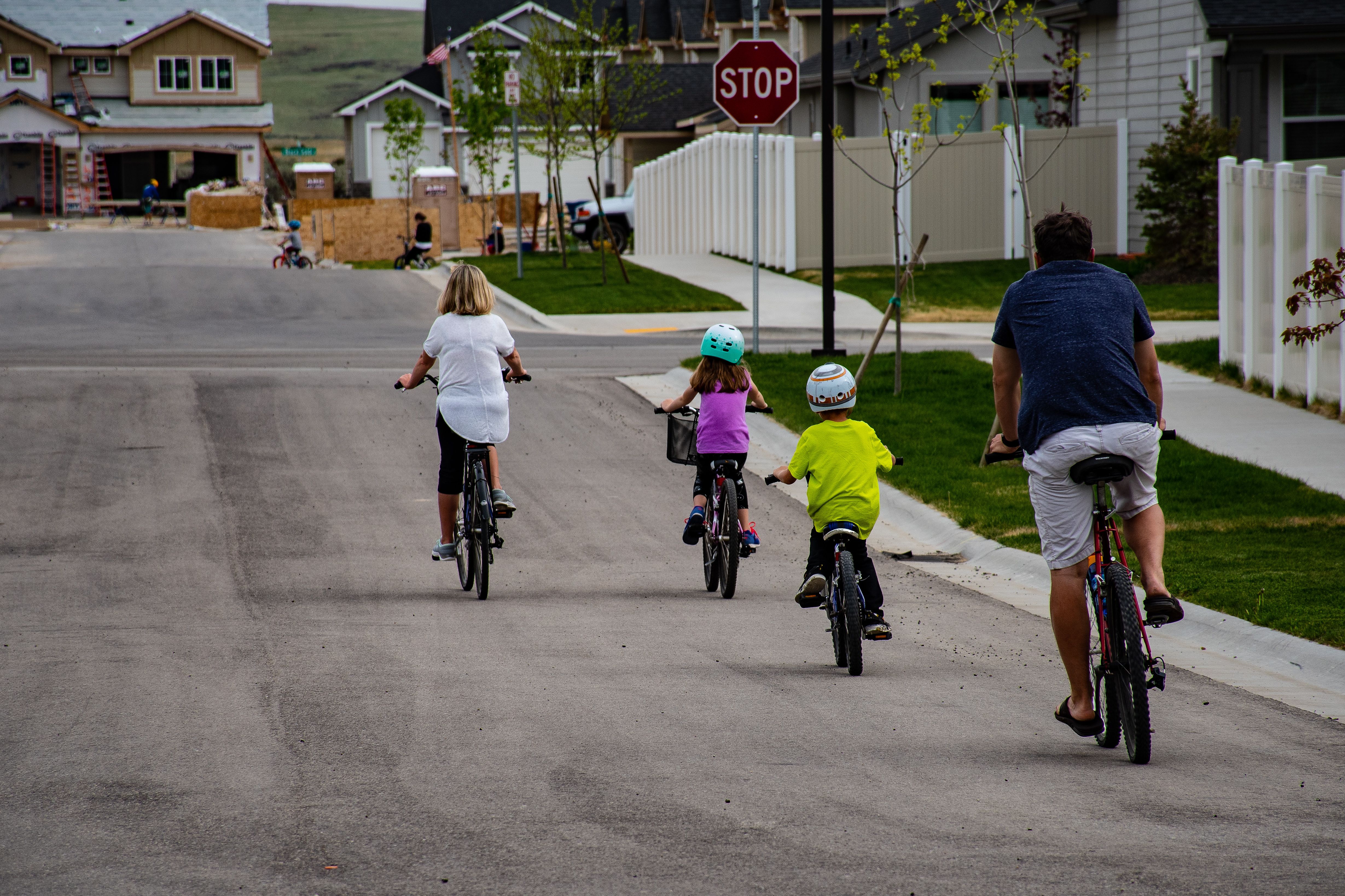 Gezin fietst samen op een rustige straat tijdens een fietsvakantie met kinderen