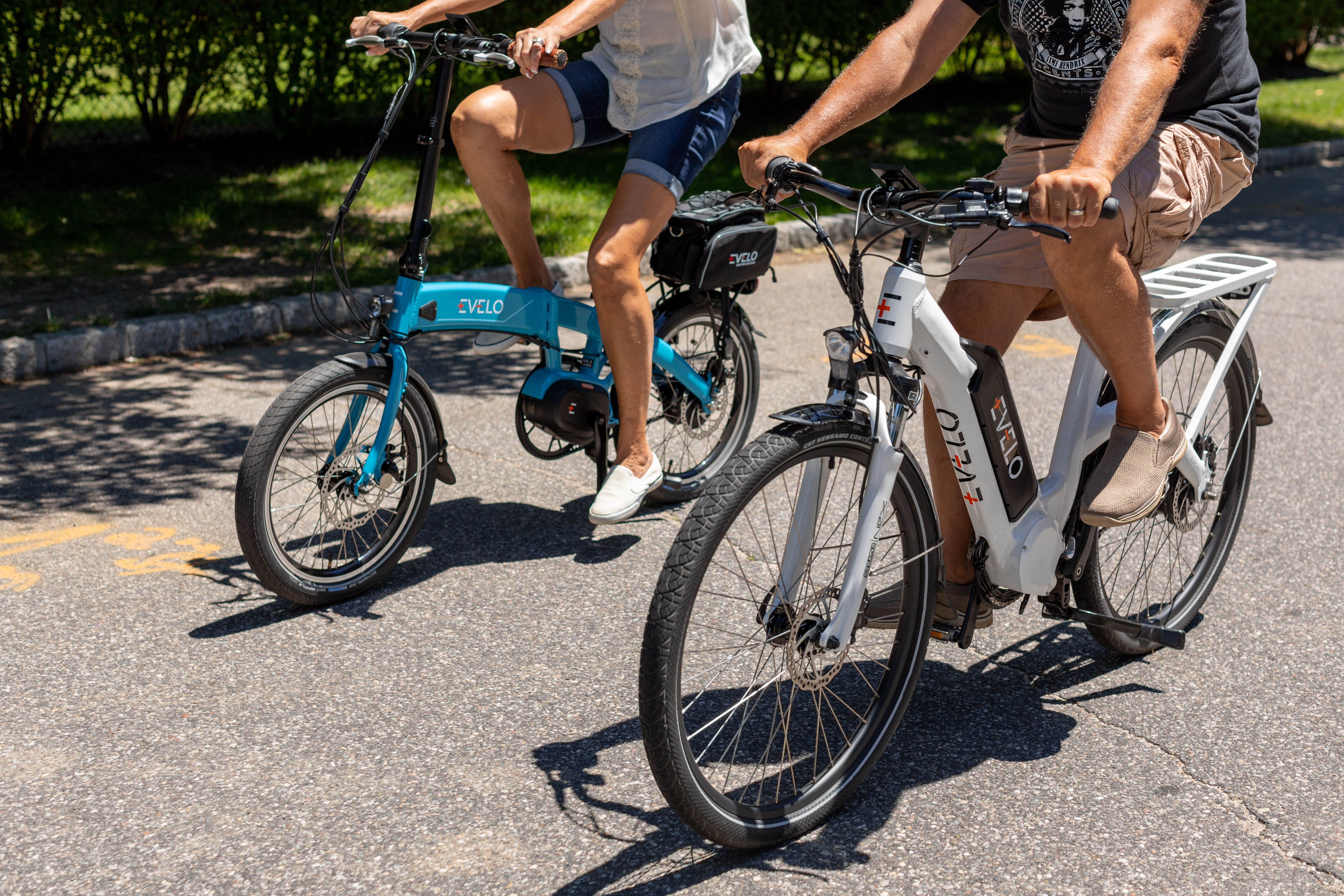 Twee fietsers rijden op e-bikes over een zonnig fietspad tijdens een fietsvakantie