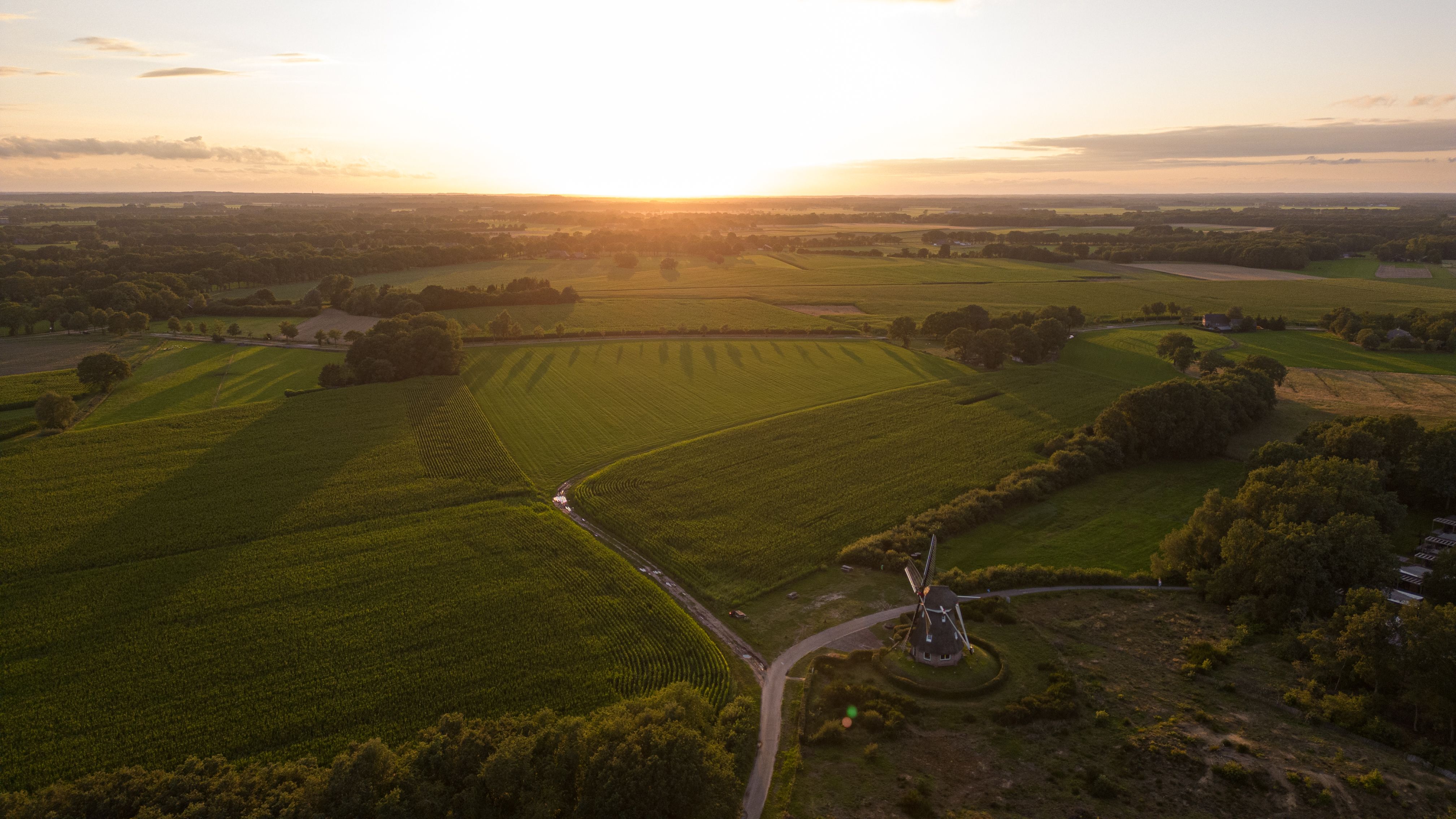 Wijd, vlak Nederlands polderlandschap bij zonsondergang, ideaal terrein voor vlakke fietsroutes